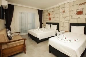 古穆杜尔Lebedos Apart Hotel的酒店客房,配有两张床和椅子
