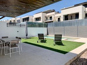 马德里Agradable chalet con piscina privada cerca de Madrid的天井配有桌椅和草地。