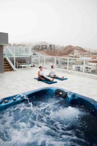 埃拉特Spa Eilat Mountain Lodge的两人坐在游泳池边