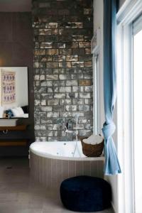 埃拉特Spa Eilat Mountain Lodge的带浴缸和砖墙的浴室