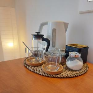 赫瓦尔Guest House Mediterranean的玻璃杯托盘和桌子上的咖啡壶