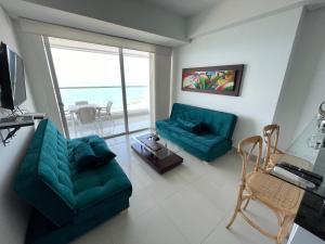卡塔赫纳Playa Cartagena Apartments的一间带两张绿色沙发的客厅和一个阳台