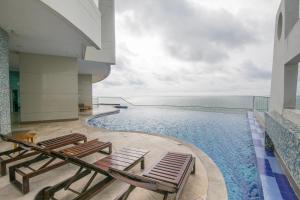 卡塔赫纳Playa Cartagena Apartments的一个带躺椅的游泳池和海洋