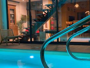 兰斯Loft Spa Reims-fr 250m2 privatifs, piscine intérieure chauffée, spa et parking的房屋内带楼梯的游泳池的景色