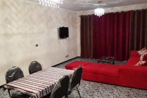 开罗Fantastic Apartment Near Cairo Airport的客厅配有红色沙发和电视