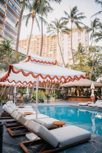 檀香山White Sands Hotel的一个带躺椅的游泳池和酒店