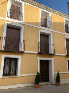 埃尔切德拉谢拉Casa Rural Casa Sagasta的带阳台和门的黄色建筑