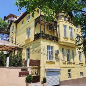 大特尔诺沃Guest House Gurkov的黄色的建筑,上面设有阳台