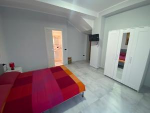 贝内文托B&B Santa Colomba的白色客房内的一间卧室配有一张多彩床