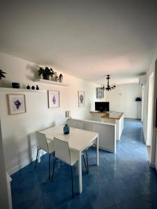 阿纳卡普里Attico Panoramico的厨房以及带白色桌椅的用餐室。