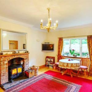 卡伦德Pinetree Cottage, dog friendly, Holiday let, Callander Invertrossachs的客厅设有壁炉和桌子