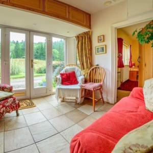 卡伦德Pinetree Cottage, dog friendly, Holiday let, Callander Invertrossachs的卧室配有床、椅子和窗户。