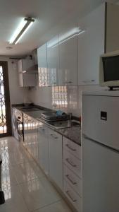 萨洛apartamento Anais的厨房配有白色橱柜和白色冰箱。