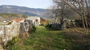 Saint-Martin-en-VercorsGîte BARD des OURS的一块石头围栏和一块田野的房子