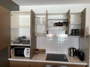 沃拉鲁Apartment 3 Wallaroo Marina的厨房配有白色橱柜和微波炉