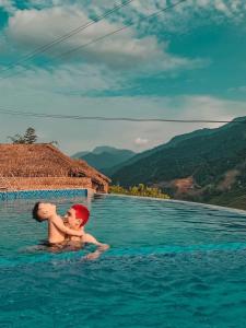 萨帕Sapa Eco Villas & Spa的两个男孩在山里的一个游泳池里