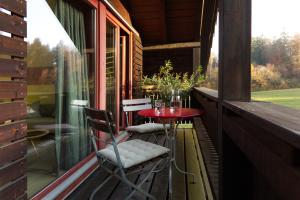 苏黎世Hausteil in einer Waldlichtung im Stadtwald的阳台配有红色的桌子和椅子。