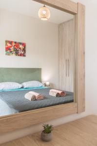 Melissátika"Thea" Valis Apartments的一间卧室配有一张带大镜子的床