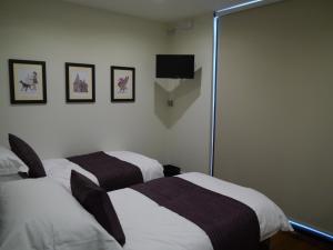 利物浦Liver View Apartments的客房设有两张床和一台墙上的电视。