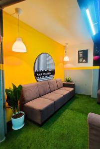 浦那Procida Hostel by Zero Jhanjhat的客厅设有棕色沙发和黄色墙壁