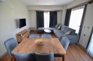 费特希耶Mykonut Erna Apart Hotel的客厅配有桌子和沙发