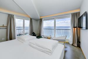 西尔米奥奈弗拉米亚酒店的卧室设有2张白色的床和大窗户