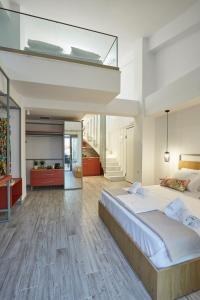 帕拉利亚狄奥尼索GreyStone Suites的一间带大床和楼梯的卧室