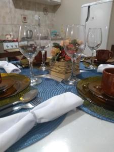 格拉玛多Casa e Flat Conforto Gramado的酒杯、盘子和餐巾的桌子