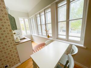 派尔努Spacious Supeluse Apartment的厨房配有白色的桌子和一些窗户。