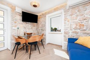 罗维尼Casa Bellavista Sea View的客厅设有蓝色的沙发和石墙