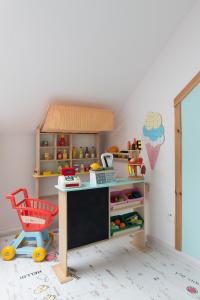 詹塔尔WILLA MAGNOLIA - Apartamenty i Pokoje - ROWERY, POKÓJ ZABAW, KAWA Z EKSPRESU的玩具厨房,配有书桌和红色椅子