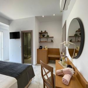 卡尼奥提萨兰提斯酒店的一间卧室配有一张床和一张带镜子的书桌