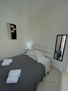 利卡斯戴勒Appartamenti Le Castella的一间卧室配有一张床,上面有两条毛巾