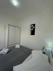 利卡斯戴勒Appartamenti Le Castella的白色的客房配有床和镜子