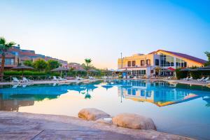 艾因苏赫纳Marina Wadi Degla Hotel的一座大型游泳池,位于拥有建筑的度假胜地