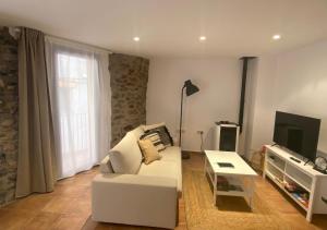 拉波夫拉-德利列特Apartamento con encanto en el Pirineo的客厅配有白色沙发和电视