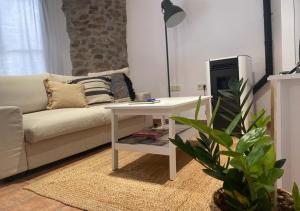 拉波夫拉-德利列特Apartamento con encanto en el Pirineo的客厅配有白色桌子和沙发