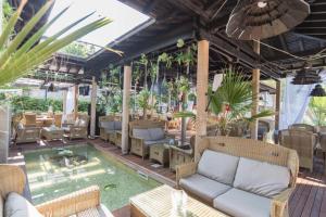 洛泽内茨Oasis Resort & Spa Cozy Studio的一个带沙发和椅子的庭院和一个游泳池