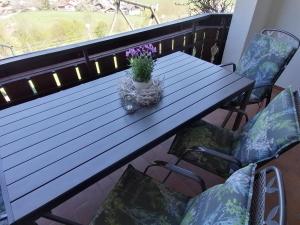 安格尔霍宾哲阿尔姆公寓酒店的阳台上的木桌和盆栽植物