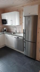 普哈圣山Skicamp 3的厨房配有不锈钢冰箱和白色橱柜