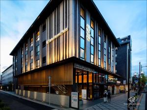 京都Daiwa Roynet Hotel Kyoto Ekimae PREMIER - former Daiwa Roynet Hotel Kyoto Ekimae的街上的一座建筑,前面的人在街上行走