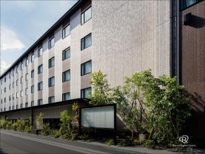 京都Daiwa Roynet Hotel Kyoto Ekimae PREMIER - former Daiwa Roynet Hotel Kyoto Ekimae的前面有广告牌的大建筑