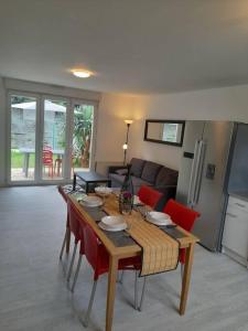 拉尼翁Appartements Lannion proche centre, Côtes de Granit Rose的客厅配有木桌和红色椅子