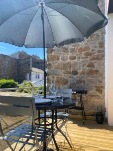 圣布里厄Les Briochines - Cocon cosy en plein centre-ville的阳台上配有带雨伞的桌子