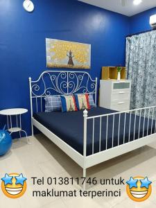 Kampong Sungai Che LiasSalju Mewah Homestay的蓝色的卧室,配有床和蓝色的墙壁