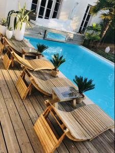 图瓦里Buddha Beach Thoiry的游泳池旁的两张木桌和椅子