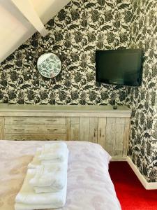 林肯Castle View Cottage的一间卧室配有一张床,墙上配有电视