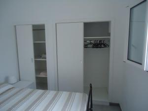 莱乌卡Appartamento Leuca的一间白色卧室,配有一张床和一个衣柜