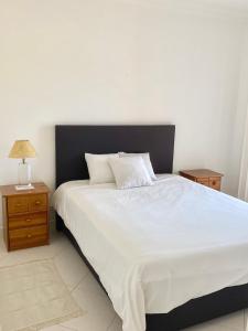 维拉摩拉Vilamoura City Center Flat的卧室配有白色大床和床头柜。