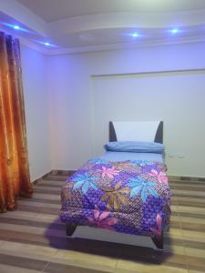 十月六日城سكن للذكور فقط - Sakan Male Only的一间卧室配有一张带彩色毯子的床